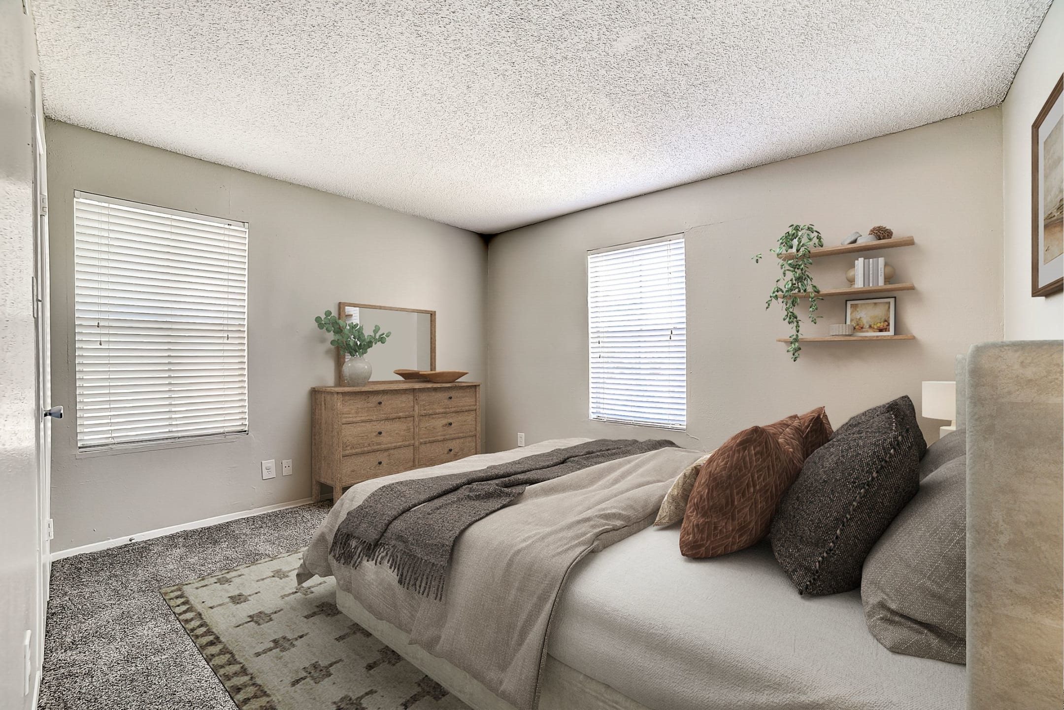 Spacious bedroom with wooden dresser and floating shelves at Peaks at Universal City Apartments, Universal City, TX