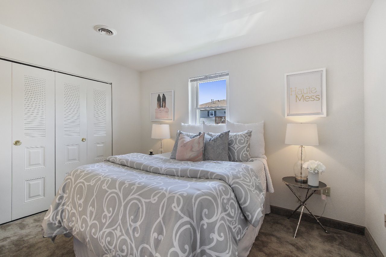 A living room with a black and white striped couch and a television.