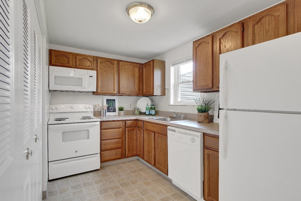 A kitchen with wooden cabinets and white appliances.