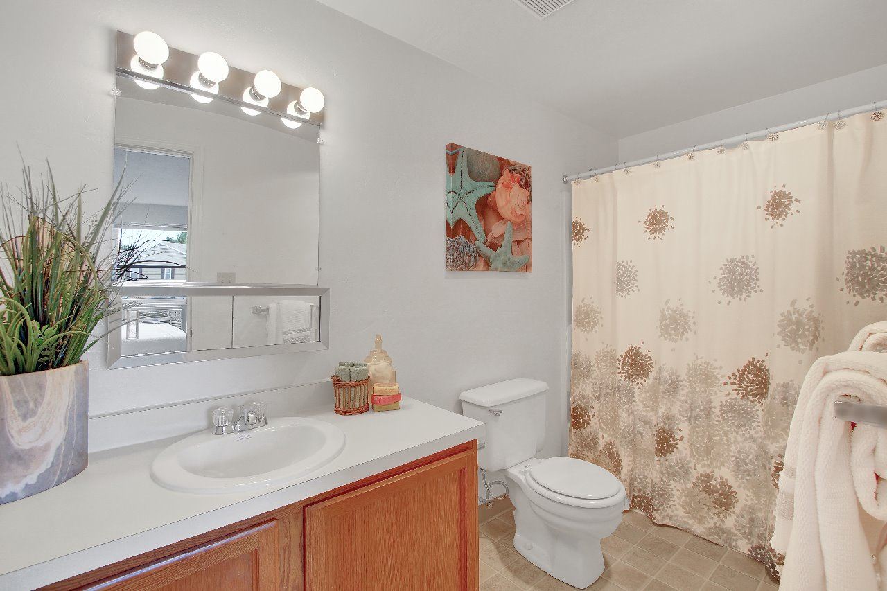 A bathroom with a toilet, sink, and shower curtain.