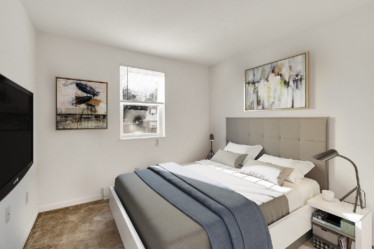 A bedroom with a large bed and two pictures on the wall.