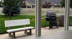a barbecue grill and a bench on a patio