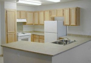 a kitchen with a white refrigerator freezer next to a stove top oven