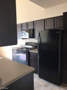 a kitchen with a stove a refrigerator and a microwave