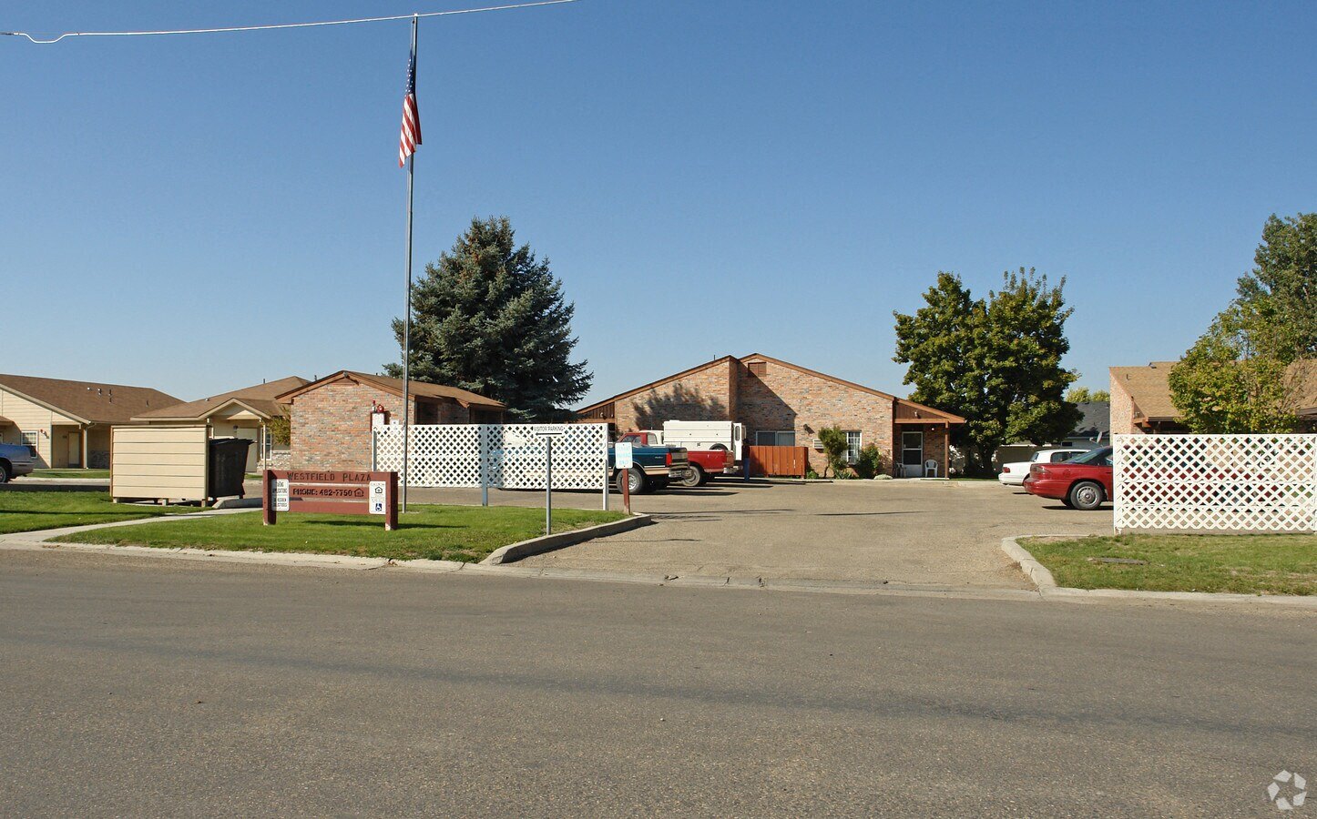 a view from the street of a house with an american flag in the front yard