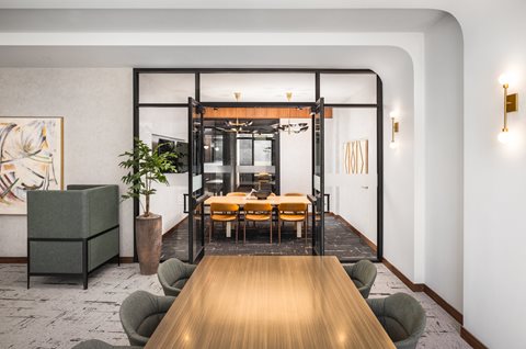 A modern dining area with a long wooden table and chairs.