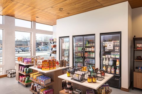 A store with a white counter and a white shelf with a variety of products on it.