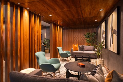 A modern living room with a wooden ceiling and a variety of seating options.