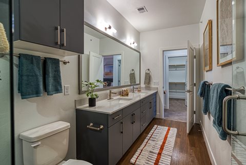 a bathroom with gray cabinets and a white toilet