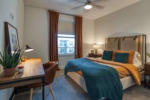 a bedroom with a bed and desk in a 555 waverly unit