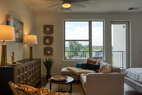 a living room with a ceiling fan and a large window
