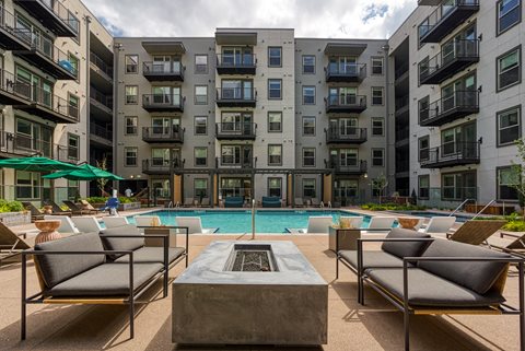 a pool area with lounge chairs and a firepit at the bradley braddock road