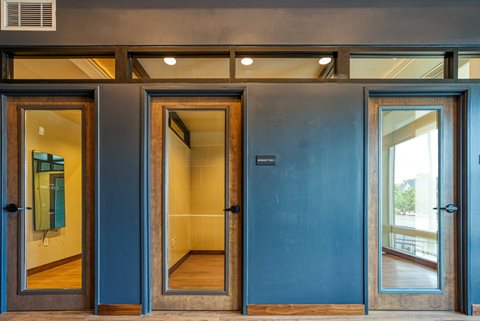 a hallway with blue doors and a yellow room in the background