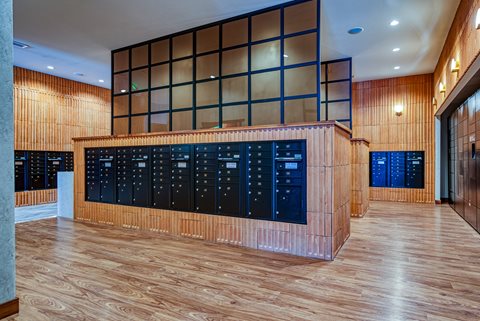 a large room with wooden floors and a large desk with a lot of lockers in it