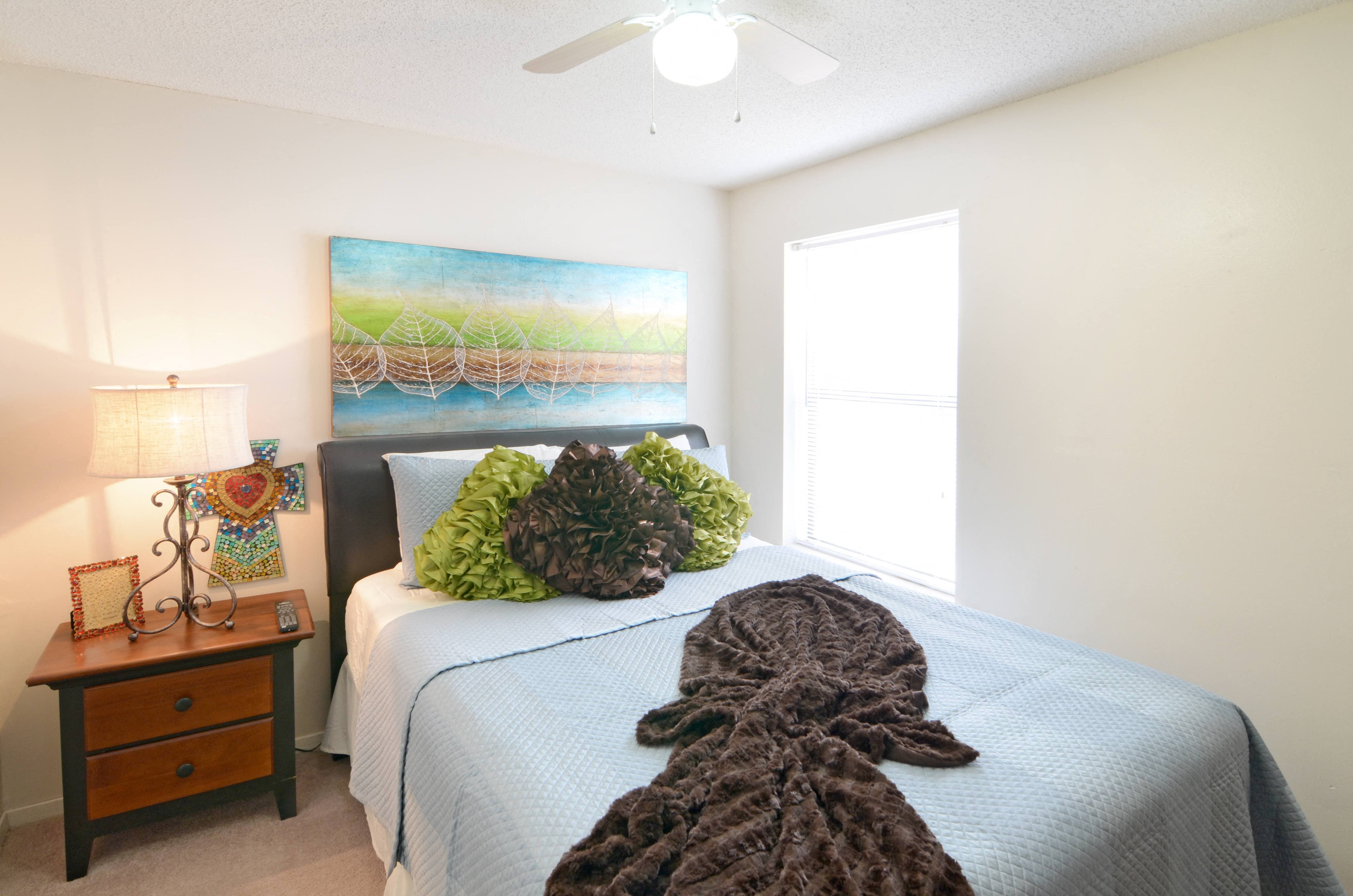 a bedroom with a bed and a ceiling fan