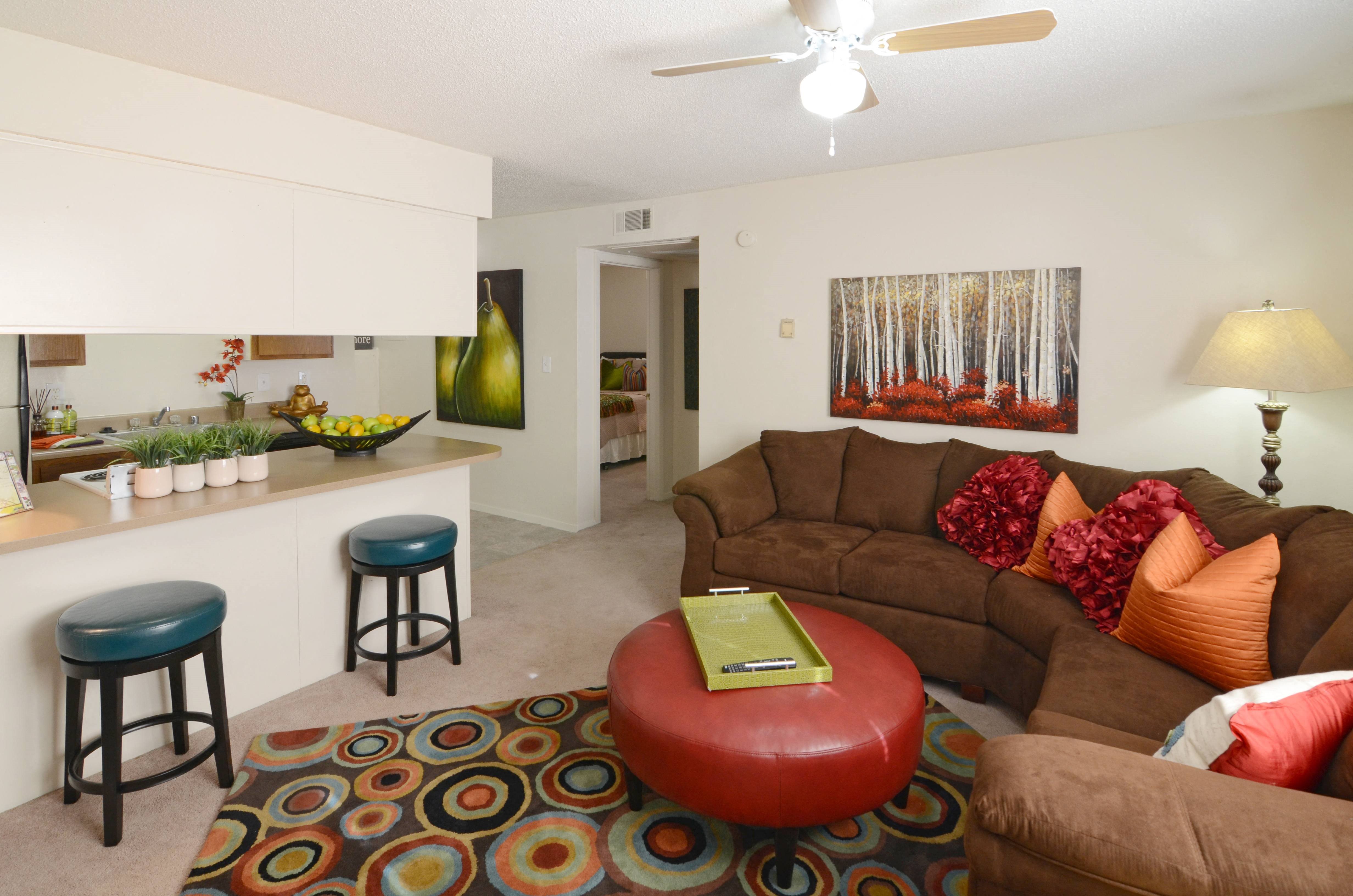 a living room with a couch and a kitchen with a counter