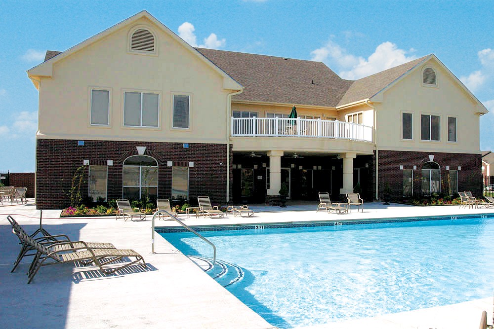 A large house with a pool in front.
