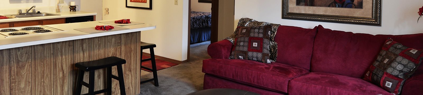 A red couch with pillows sits in a living room.
