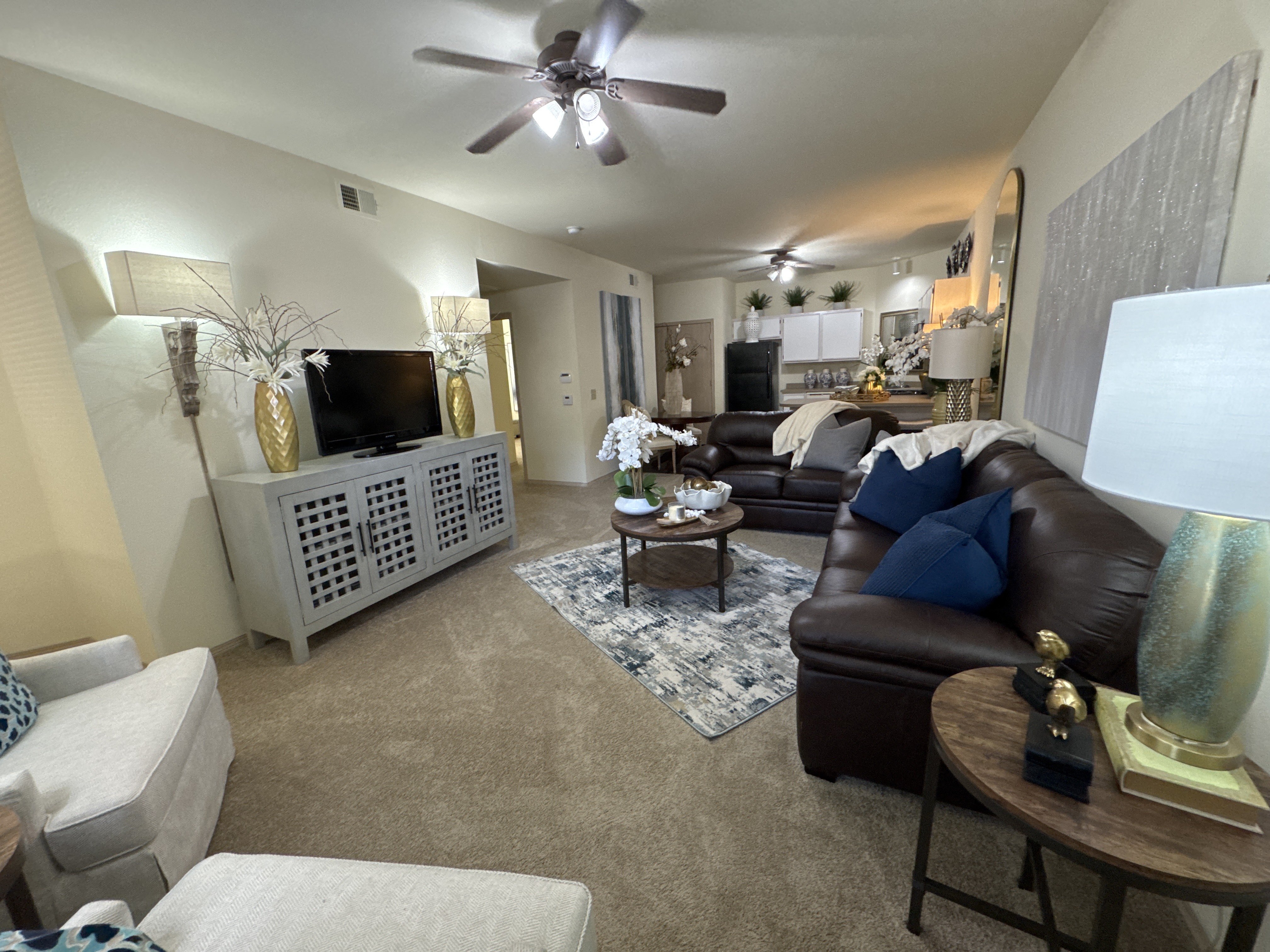 A living room with a brown leather couch and a white entertainment center.