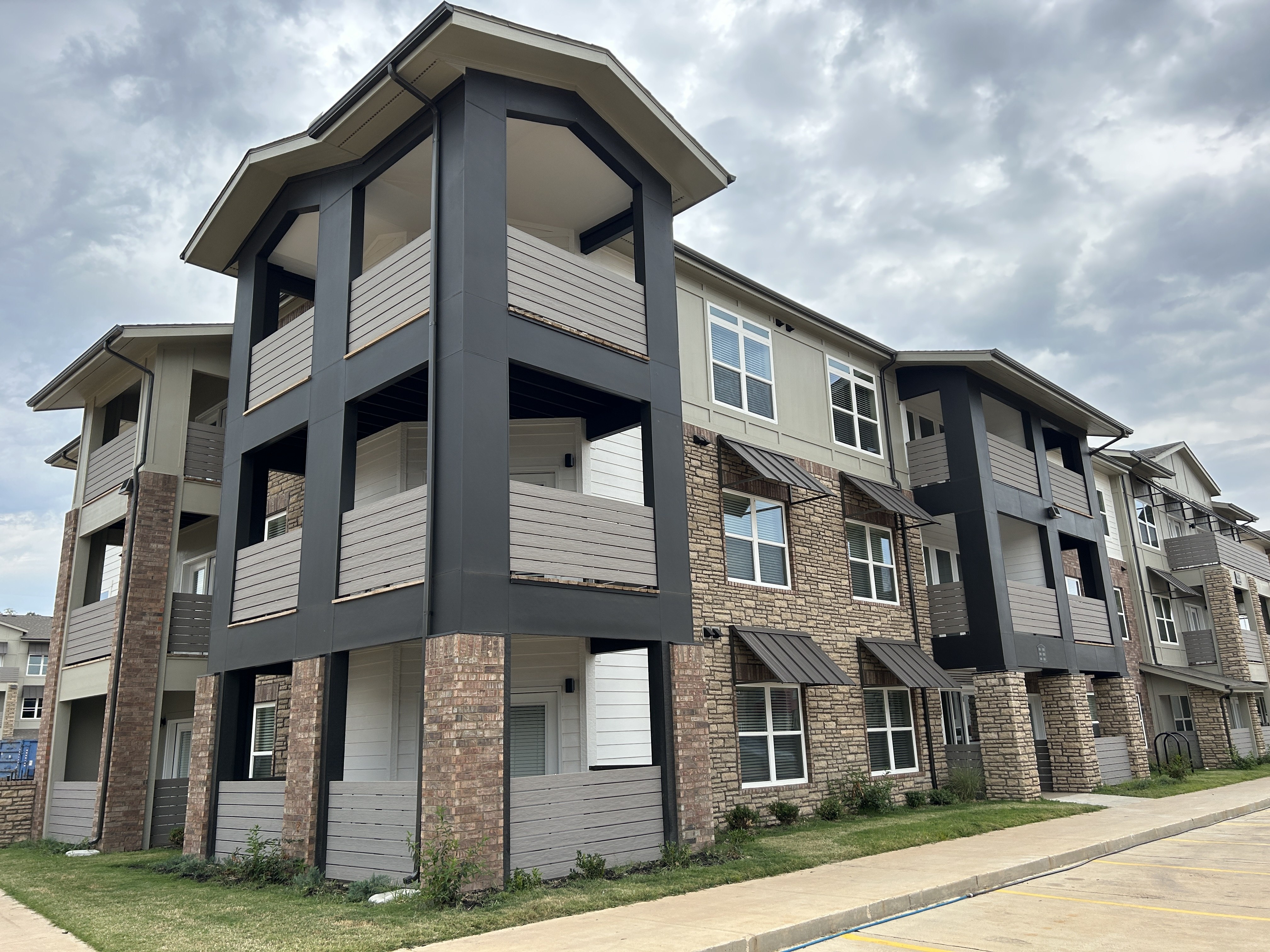A modern apartment building with a mix of brick and siding exterior.
