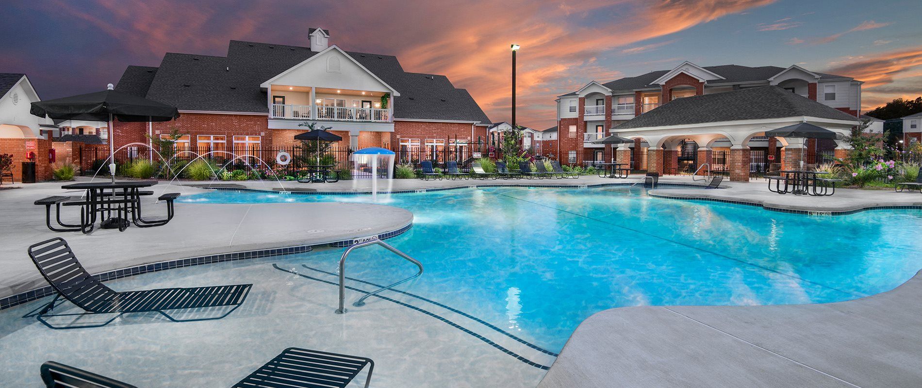 apartments with a large swimming pool at dusk