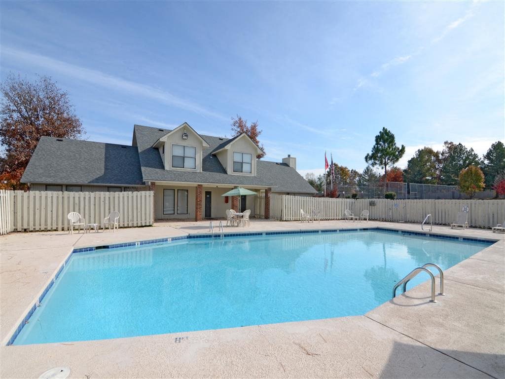 a swimming pool with a house in the background