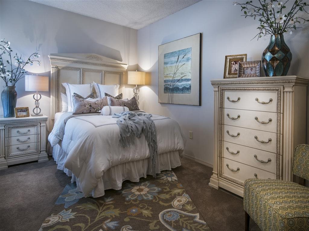 A bedroom with a large bed and a dresser.