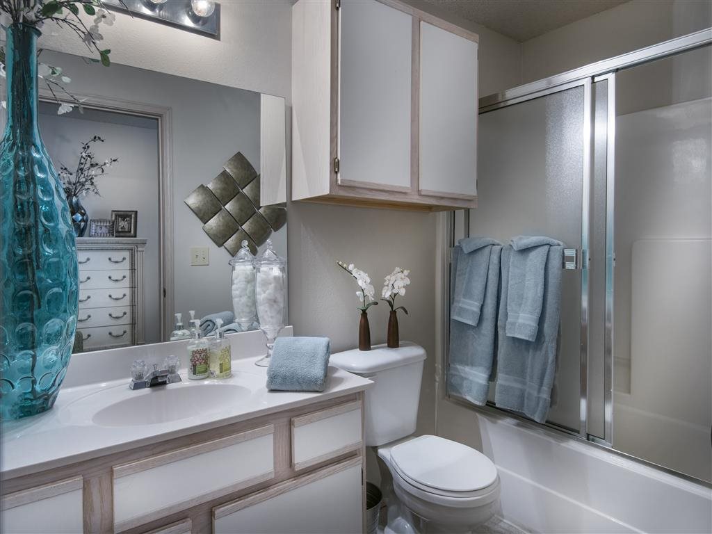 A bathroom with a white toilet, a sink, and a shower.