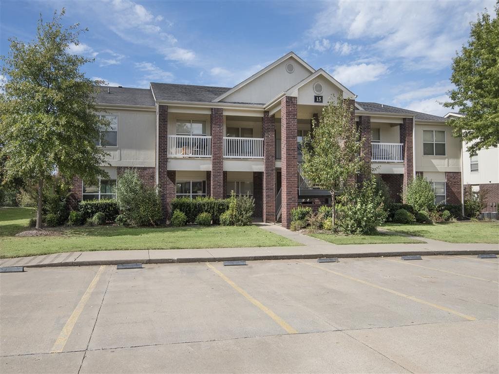 Apartment building with a parking lot in front.
