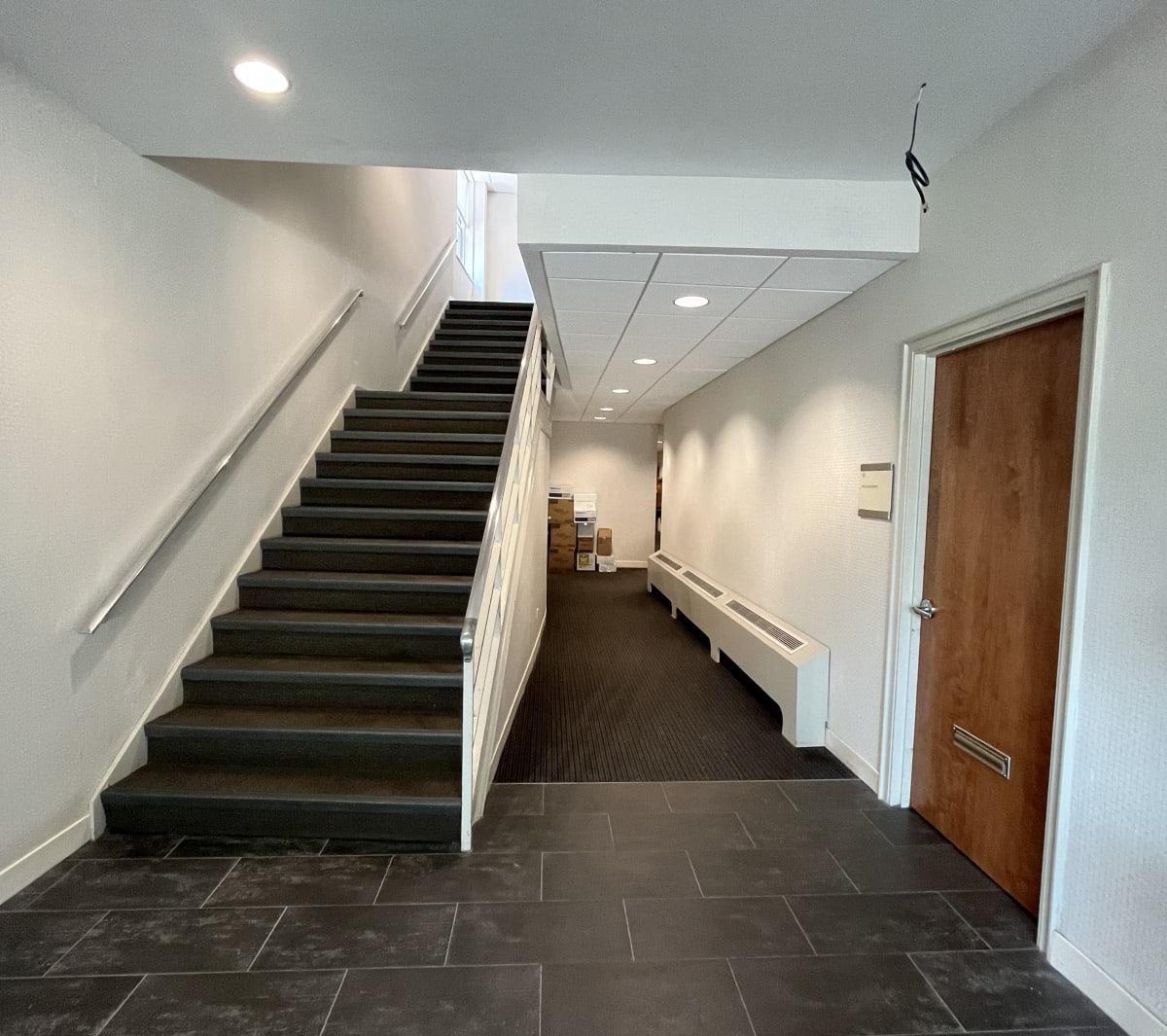 A hallway with a staircase and a door.