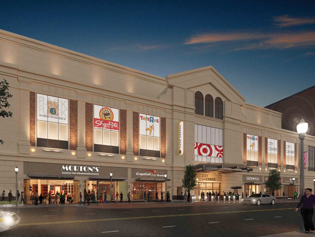 A large building with a lot of stores on the ground floor.