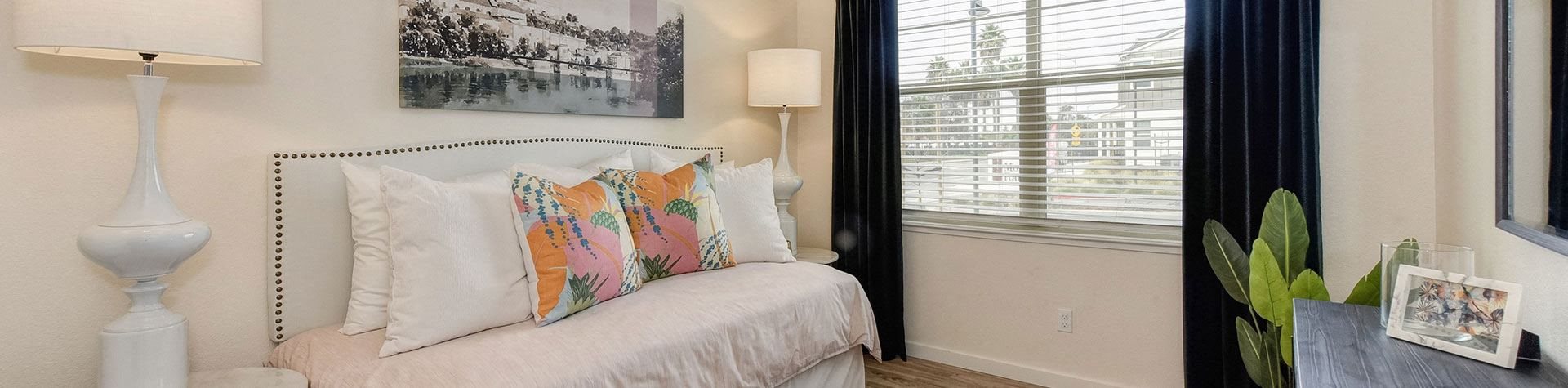 a bedroom with a bed with pillows and a window