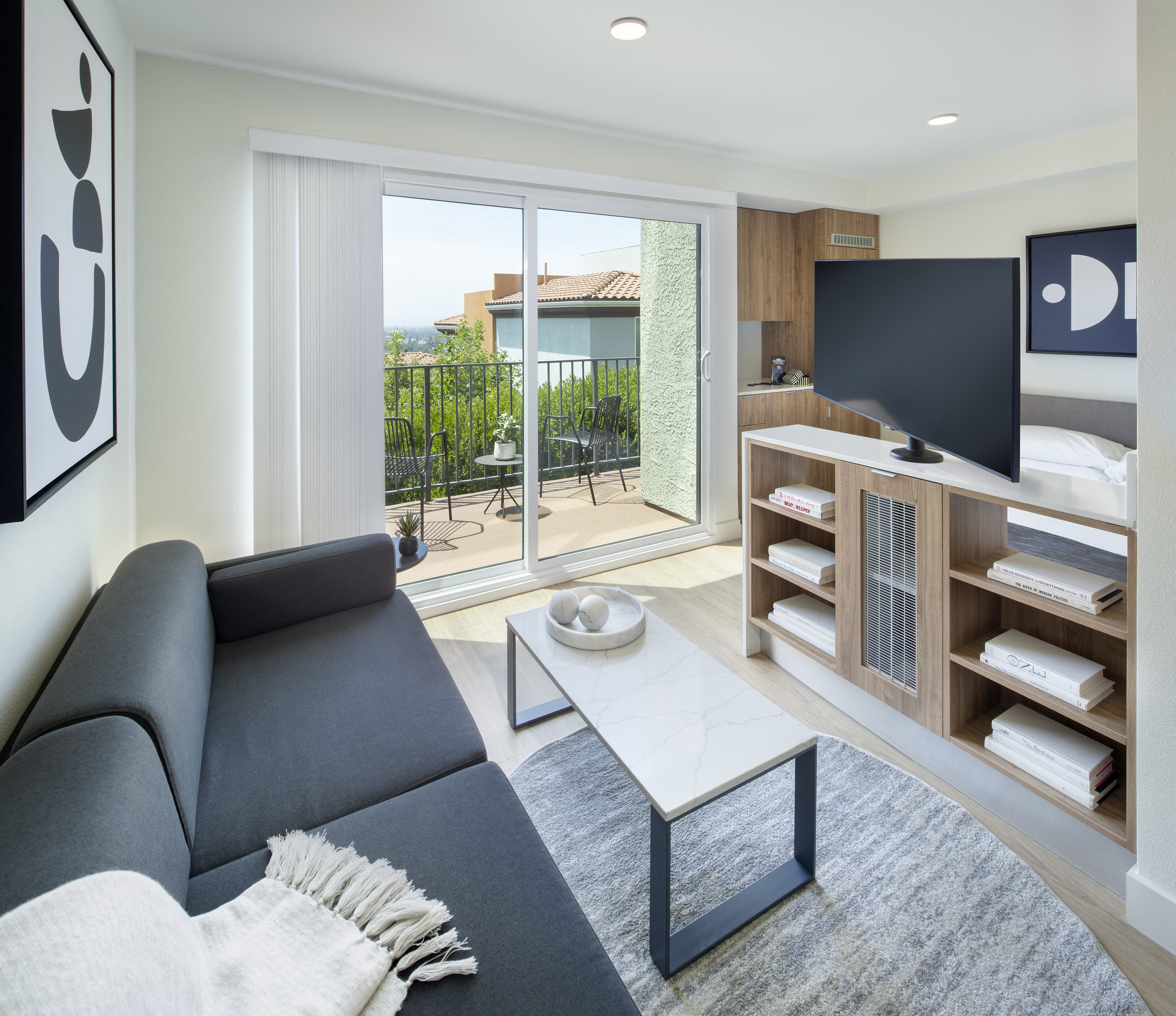 a bedroom with a tv on top of a bookshelf
