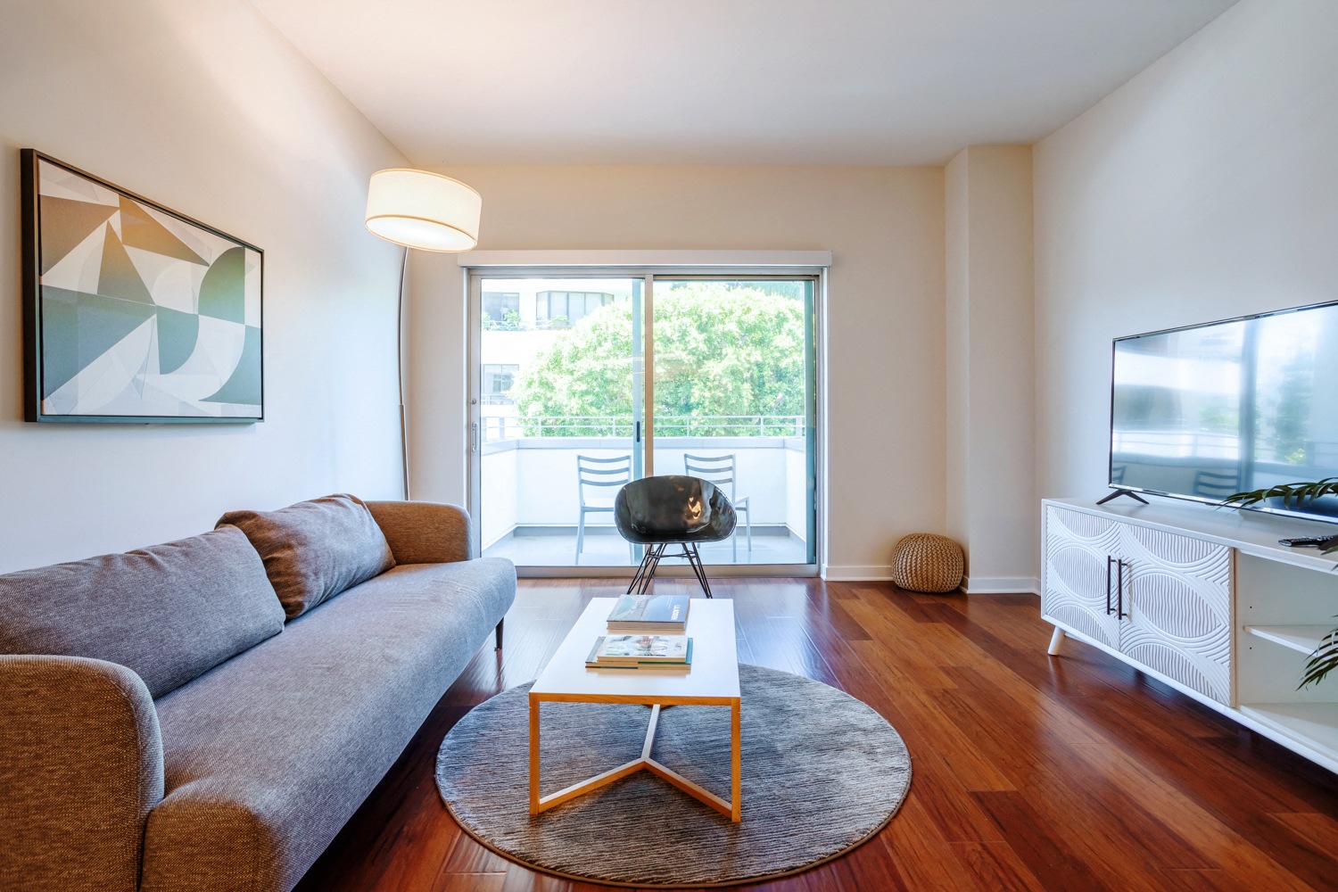 a living room with a couch coffee table and a kitchen in the background