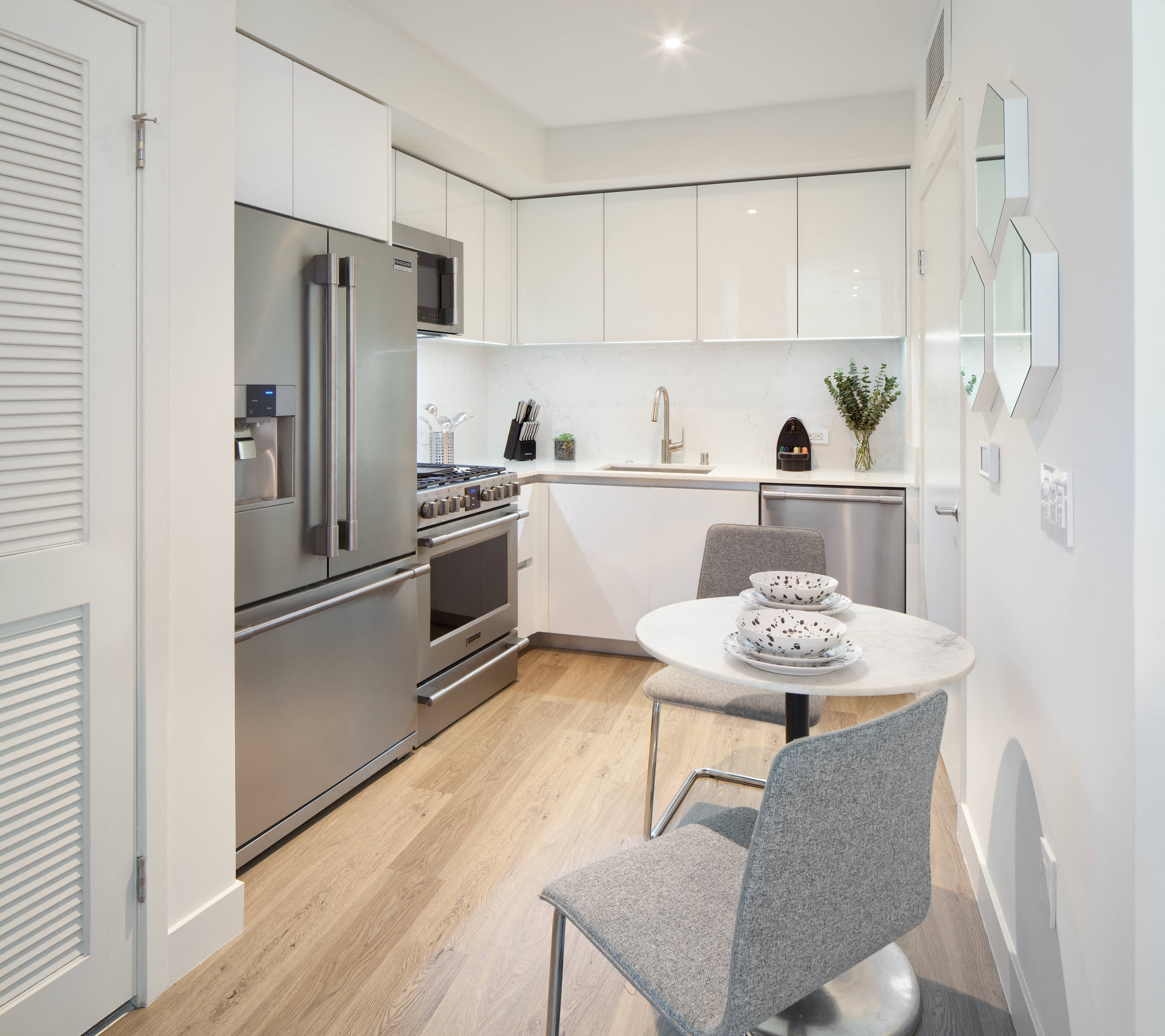 a kitchen with white cabinetry and stainless steel appliances