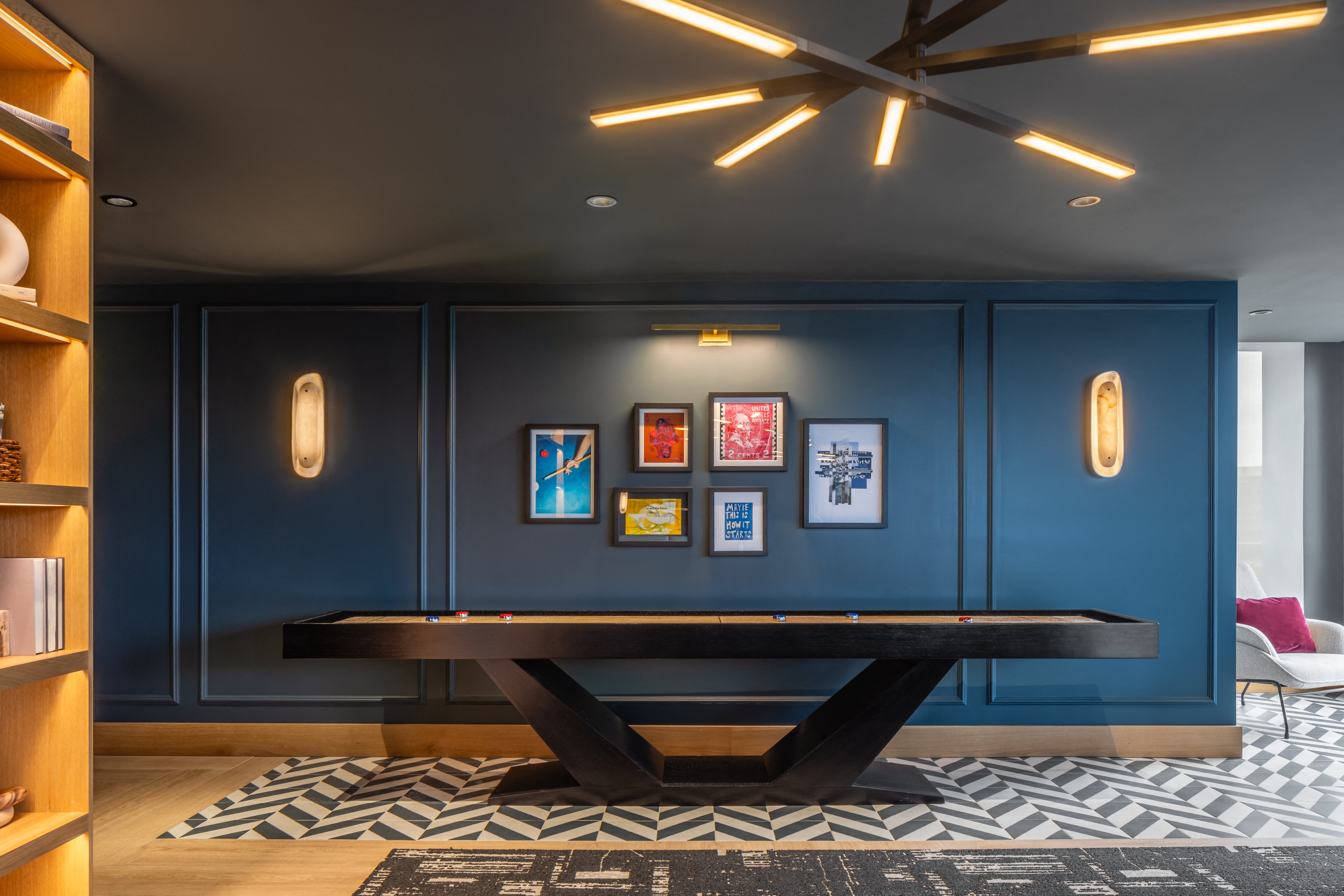 A room with a blue wall and a black and white patterned rug.