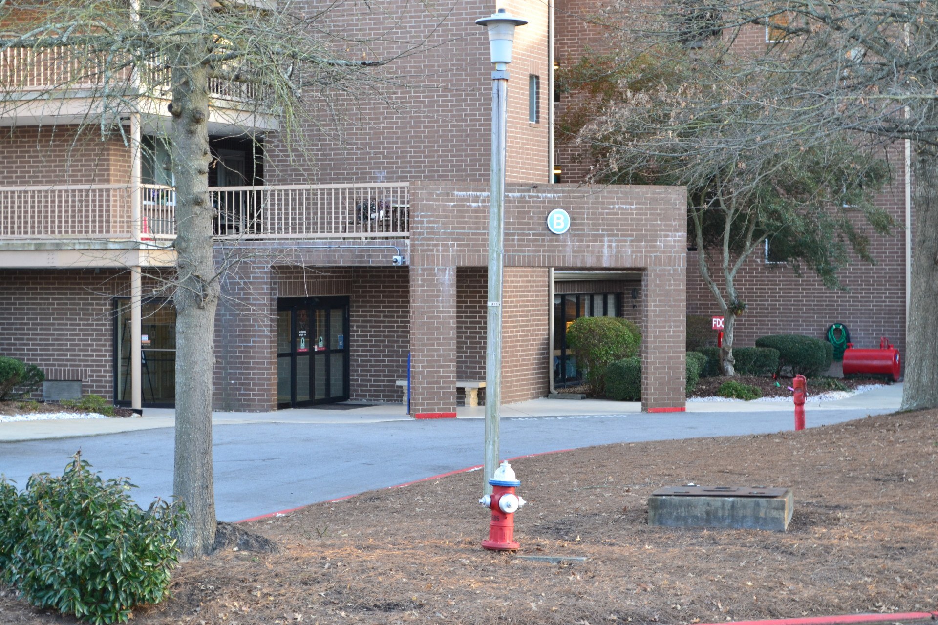 a red and white fire hydrant in front of a brick building