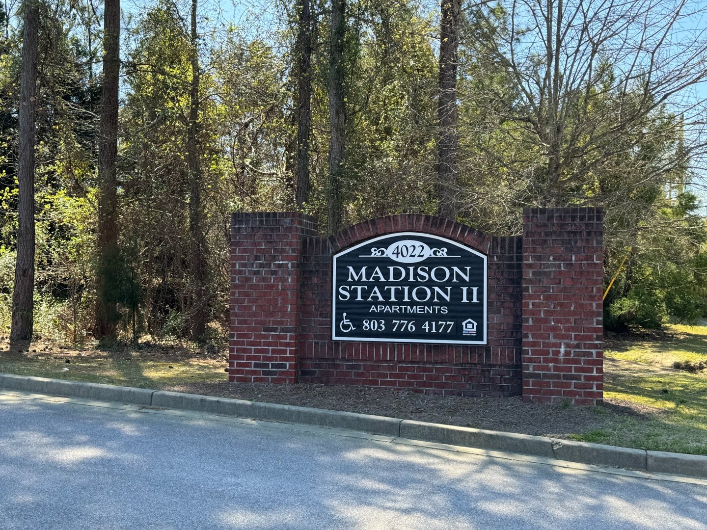 A sign for Madison Station II Apartments stands in front of a wooded area.,A sign for Madison Station II Apartments stands in front of a wooded area.,A sign for Madison Station II Apartments stands in front of a wooded area.