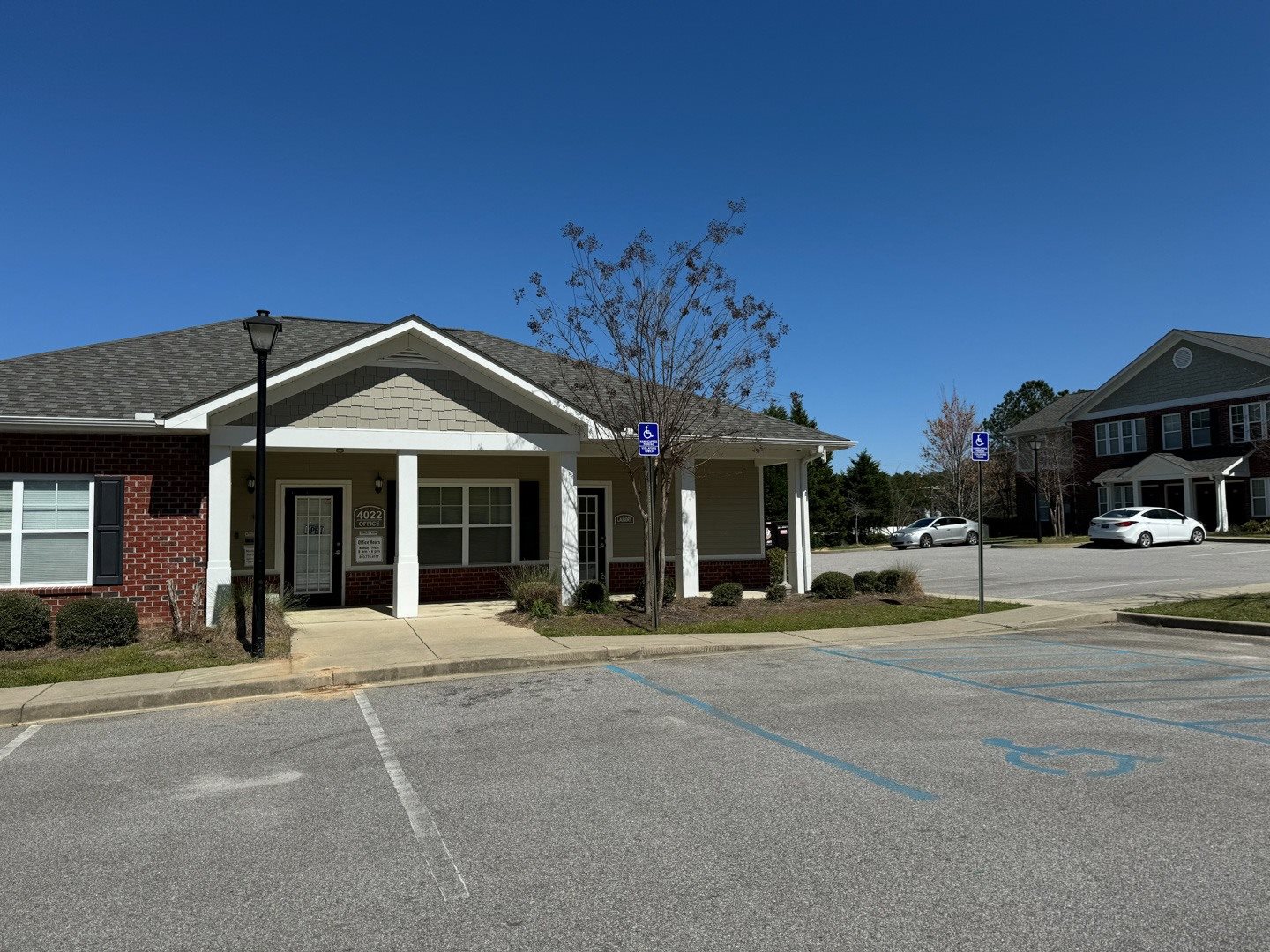 A building with a parking lot in front of it.,A building with a parking lot in front of it.,A building with a parking lot in front of it.