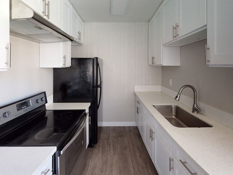Kitchen With White Cabinetry And Black Appliances at Occidental Apartments, Los Angeles, CA