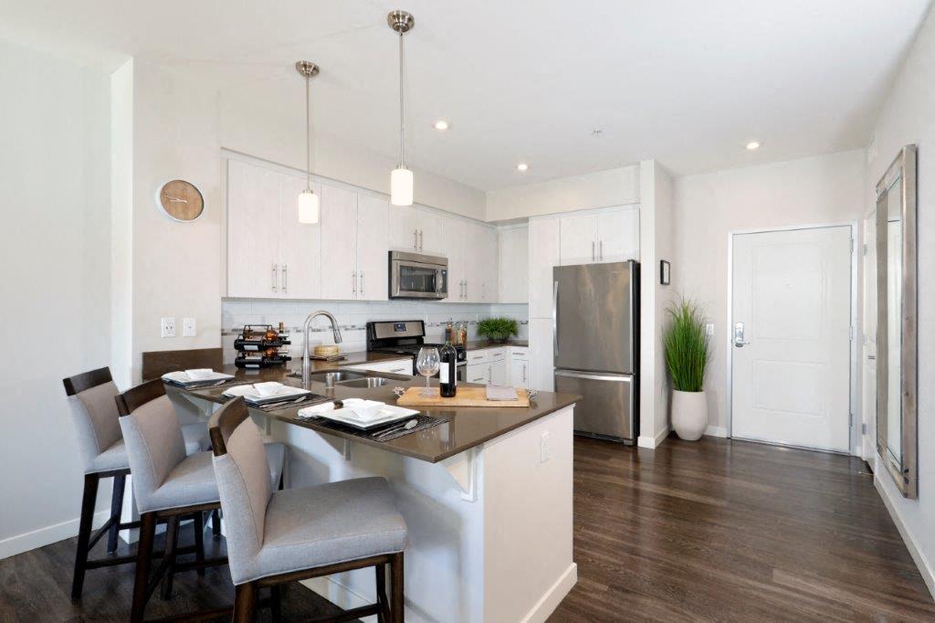 a kitchen with a large island and a stainless steel refrigerator
