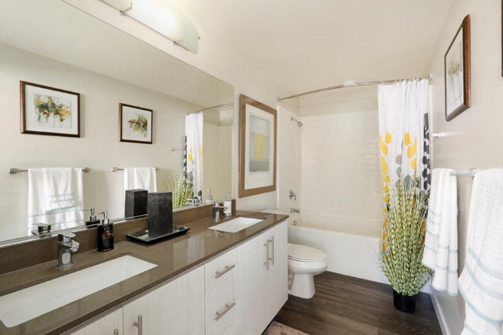 a bathroom with two sinks and a toilet and a mirror