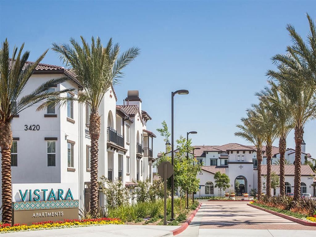 a street with palm trees in front of some apartments
