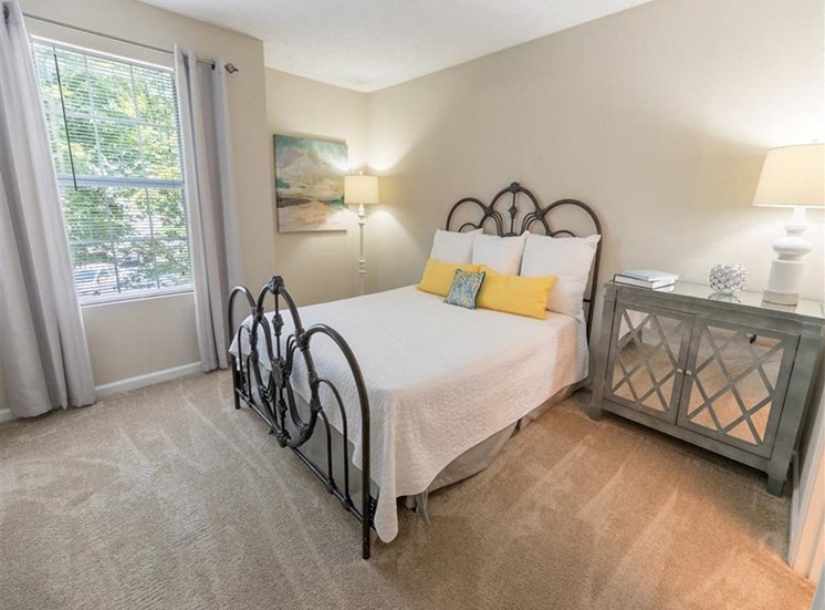 bedroom with plush carpeting, large window, and model furnishings at Stillwater at Grandview Cove, Simpsonville, 29680