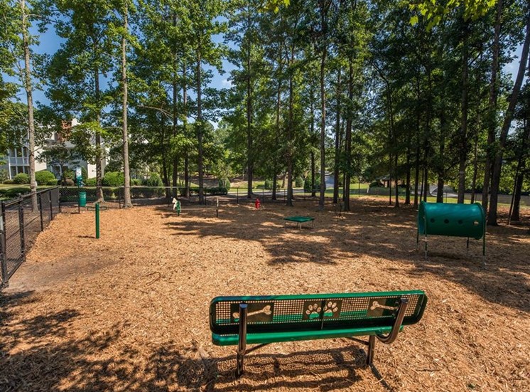 Large fenced bark park with benches and agility course objects at Stillwater at Grandview Cove, South Carolina, 29680