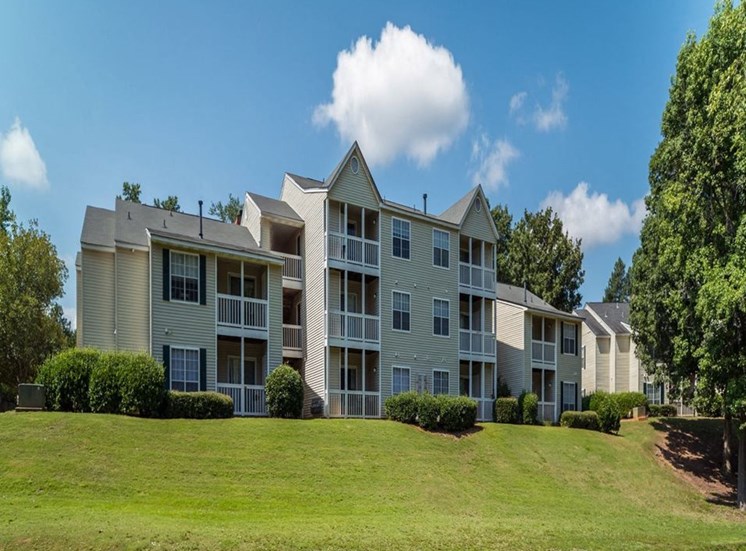 three story apartment building surrounded by mature landscaping at Stillwater at Grandview Cove, Simpsonville