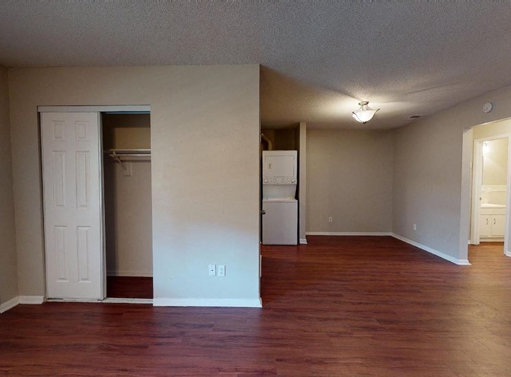 living room with coat closet, and washer and dryer beside kitchen