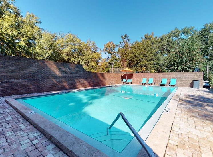 Swimming pool with tiered entrance and lounge chairs on pool deck at Aspen Run and Aspen Run II Apartments, Tallahassee, FL