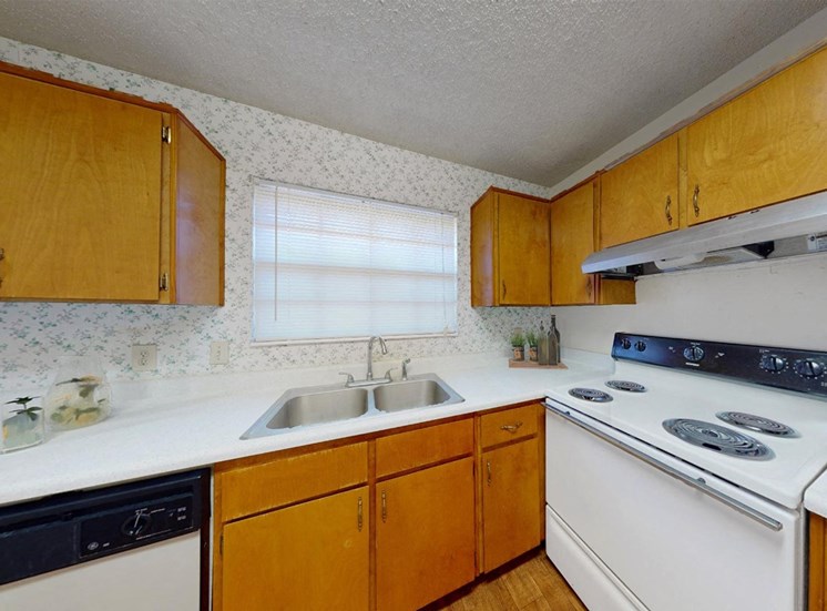kitchen with window over sink, ample cabinetry, and white appliance package