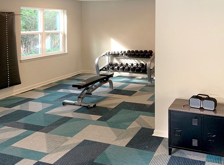 free weights, weight bench, and yoga mats in fitness center